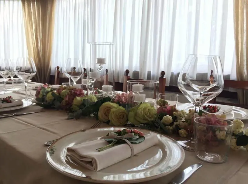 Mise en place con composizione floreale e dettagli in verde