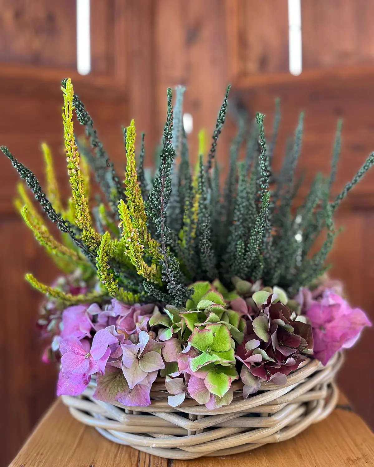 Cesto di vimini con erica e ortensie rosa e verdi