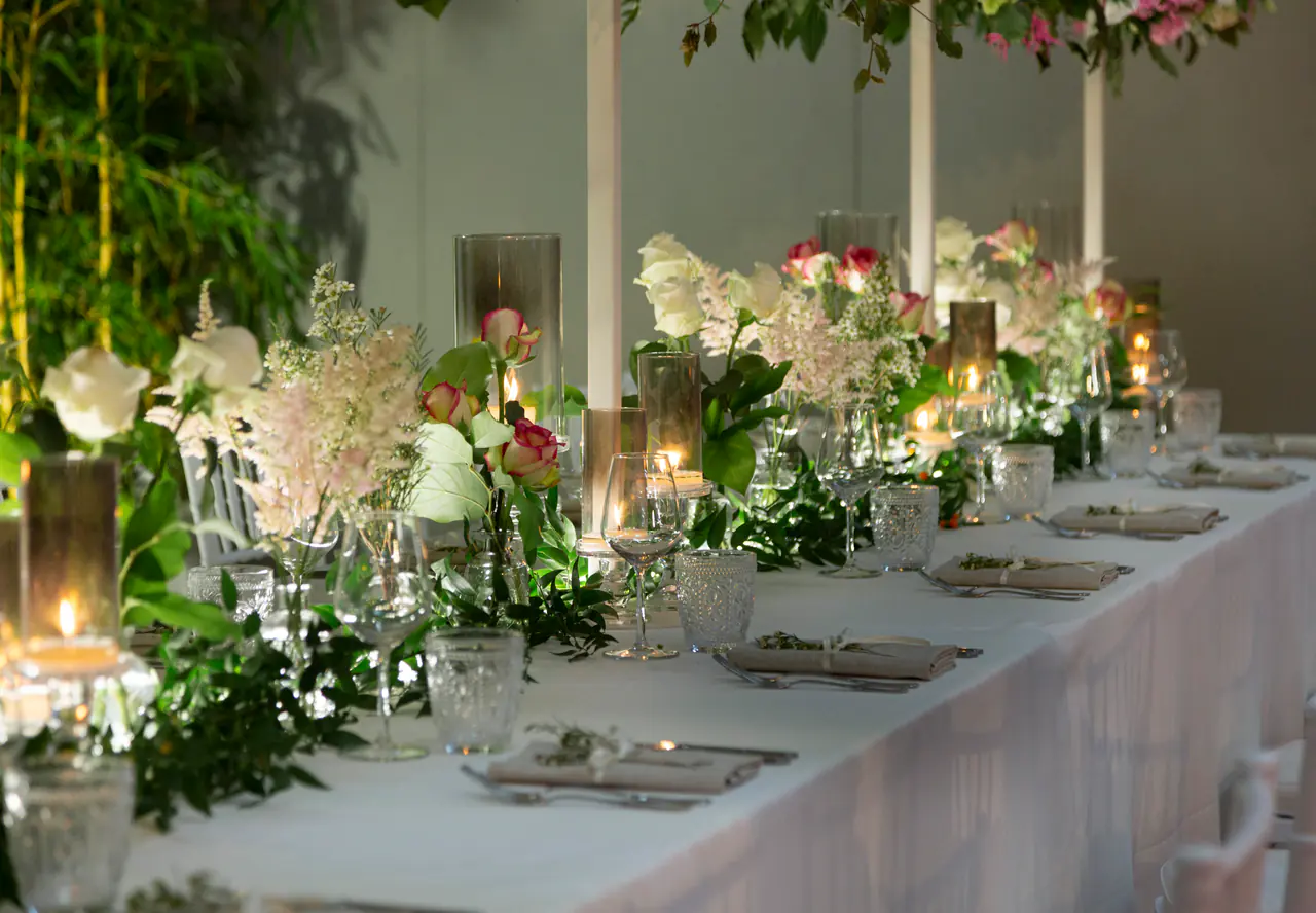 Tavola imperiale con candele e centrotavola di rose e ortensie bianche