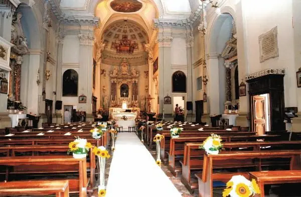 Navata addobbata con girasoli sui banchi e tappeto bianco