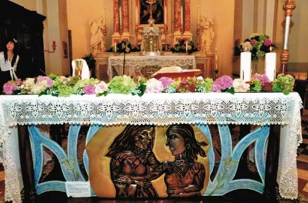 Altare rivestito da una fascia di fiori bianchi e rosa