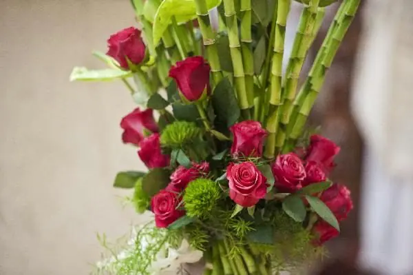 Composizione con rose rosse, bambù e verde strutturale