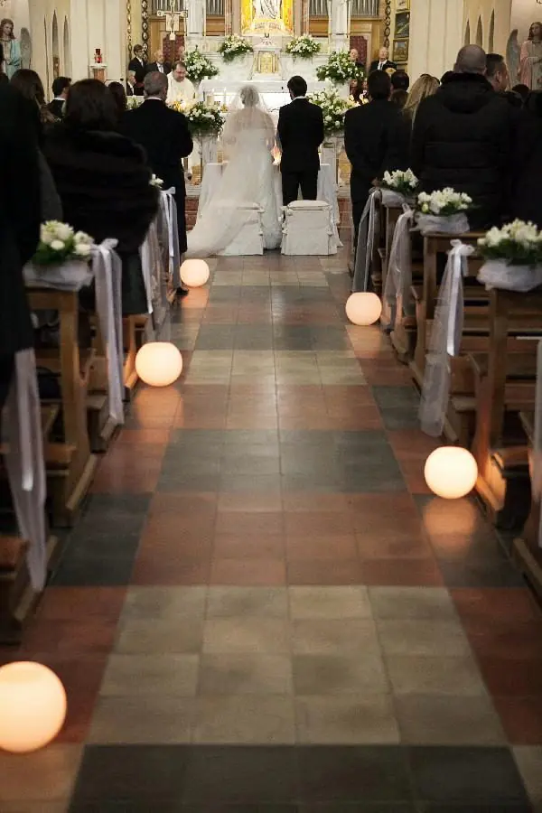 Navata con sfere luminose e composizioni bianche sui banchi