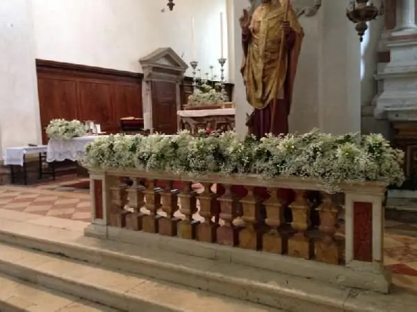 Fascia di gypsophila e fiori bianchi lungo la balaustra dell'altare