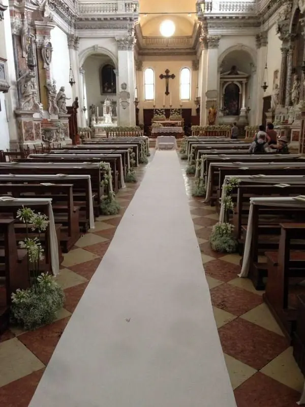 Tappeto bianco e composizioni verdi lungo tutta la navata