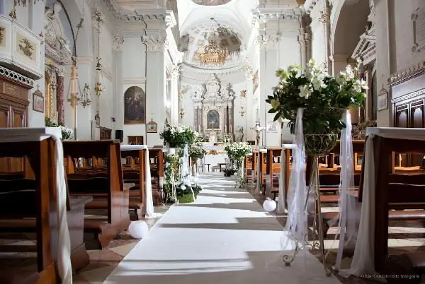 Chiesa barocca con alzate fiorite e drappi lungo la navata