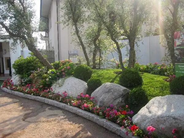 Bordura con massi di granito, bosso a sfera e fioriture stagionali