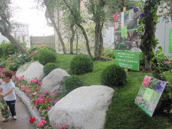 Giardino con grandi massi naturali, prato e macchie di colore